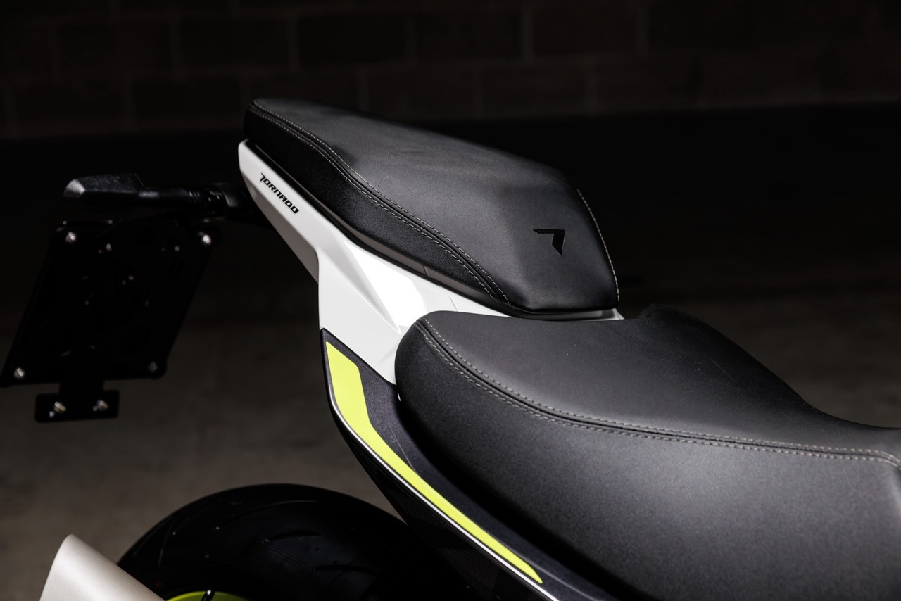 Benelli-tornado-550 3 - AutoBike Close-up of a sport motorcycle seat and rear fairing, featuring black seat, white frame, and neon yellow accents. - AutoBike