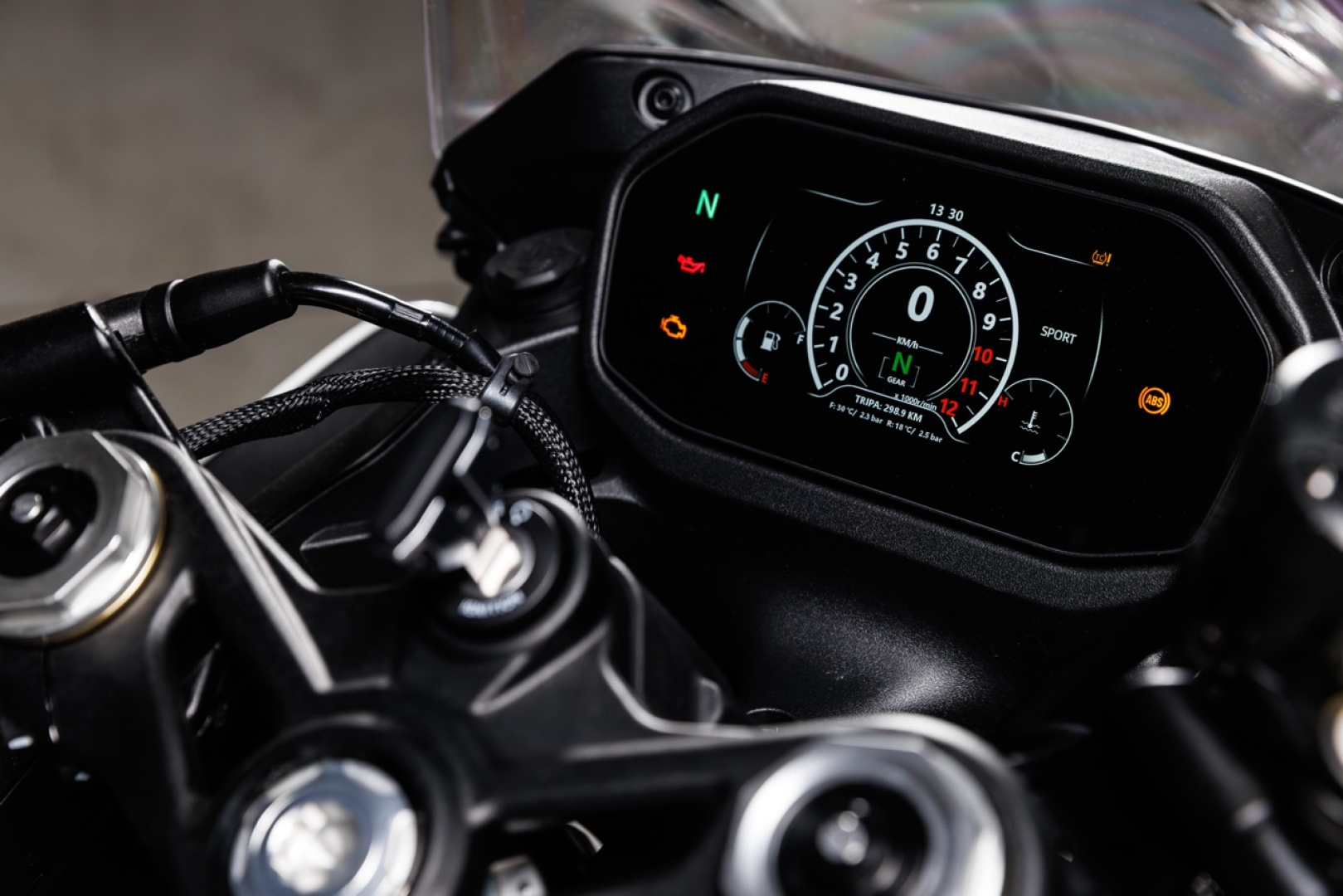 Benelli-tornado-550 3 - AutoBike Close-up of a motorcycle digital dashboard showing speedometer, gear indicator (N), and warning lights with handlebars in the foreground. - AutoBike