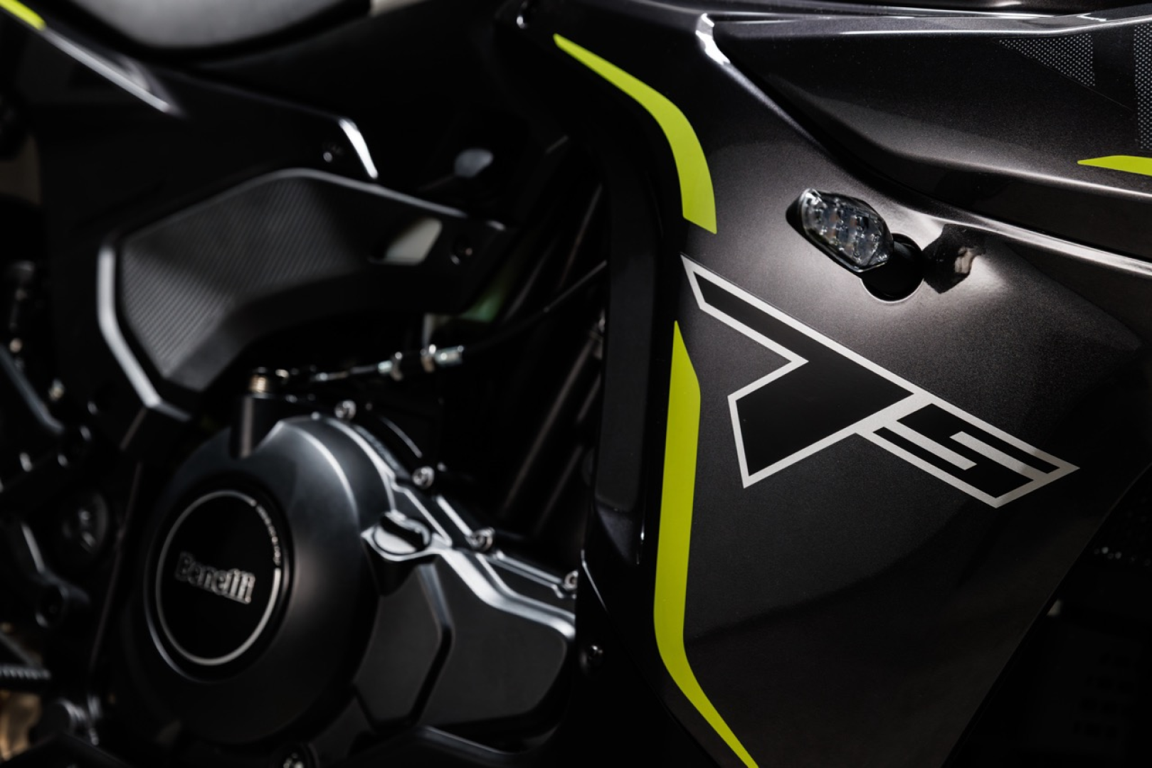 Benelli-tornado-550 4 - AutoBike Close-up of a black sport motorcycle side panel with neon yellow accents and a large white geometric logo over the fairing. - AutoBike