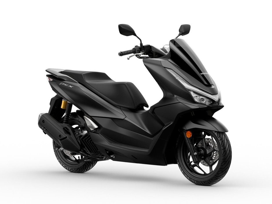 honda-pcx-125 - AutoBike Black Honda PCX scooter photographed from the left side, showing its sleek aerodynamic design and single-seat configuration - AutoBike