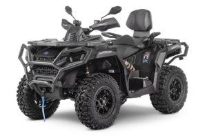 Black rugged four-wheeled ATV with a protective front bumper, large knobby tires, and a padded passenger seat; shown from a front-right angle with a blue tow strap visible at the hitch (for off-road use).]]}