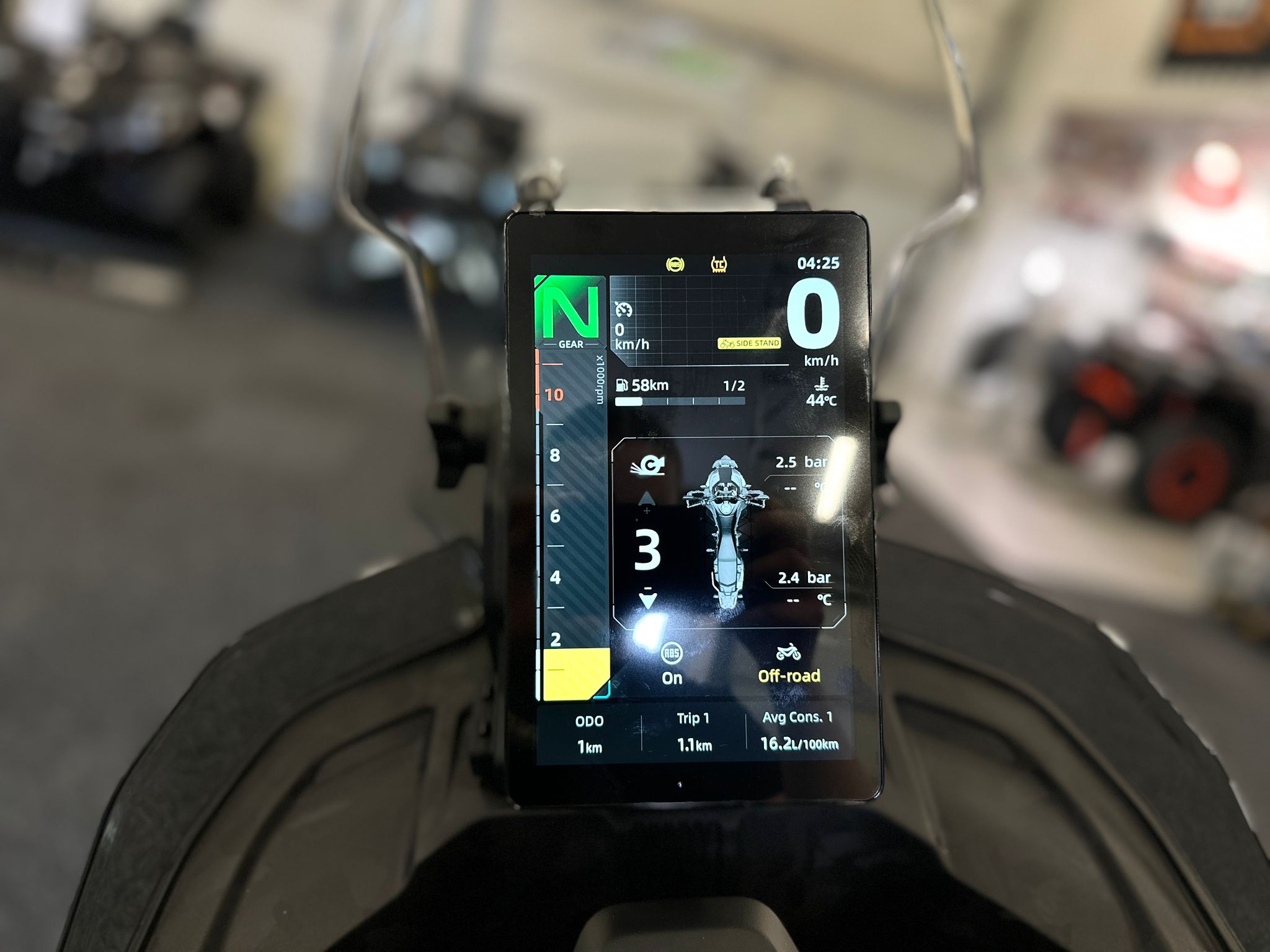 CFMOTO-1000-MT-X-1-18 at 203524 4 - AutoBike Close-up of a motorcycle digital dashboard on the handlebars showing gear N, speed 0 km/h, and trip data. - AutoBike