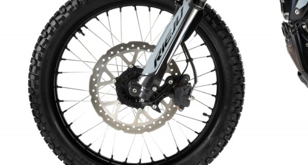 Close-up of a dirt bike front wheel with knobby tire, disc brake rotor, and fork. - AutoBike
