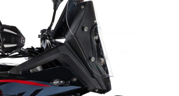 Close-up of a black motorcycle's front end, showing the headlight assembly and windshield with red/blue fairing detail - AutoBike