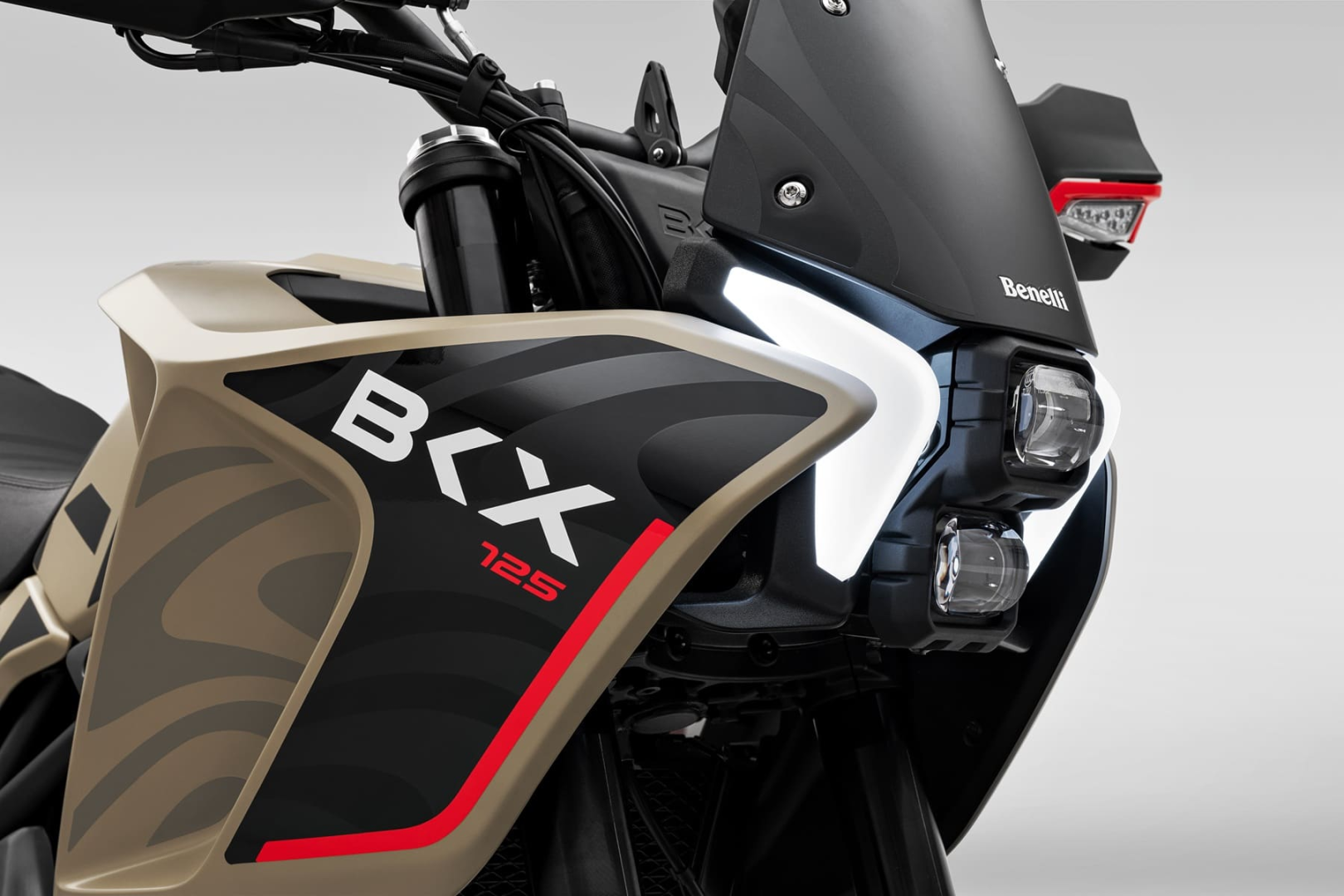 Benelli-bkx-125-s 1 - AutoBike Close-up of a Benelli motorcycle front bodywork, showing beige and black panels with red accent and the 'BKX 125' logo. - AutoBike