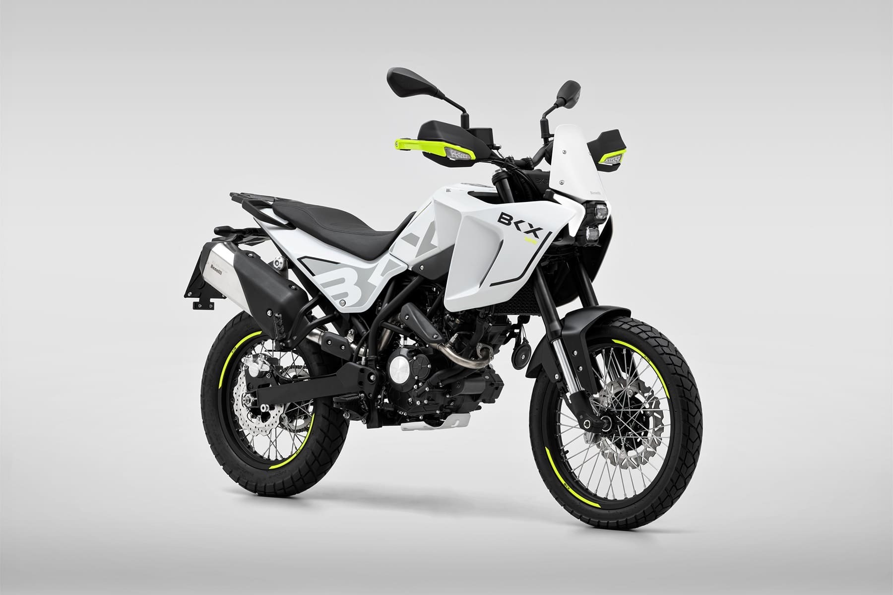 Benelli-bkx-125-s 4 - AutoBike White adventure motorcycle with black frame and neon-yellow accents, shown from a left-front side view on a gray backdrop. - AutoBike