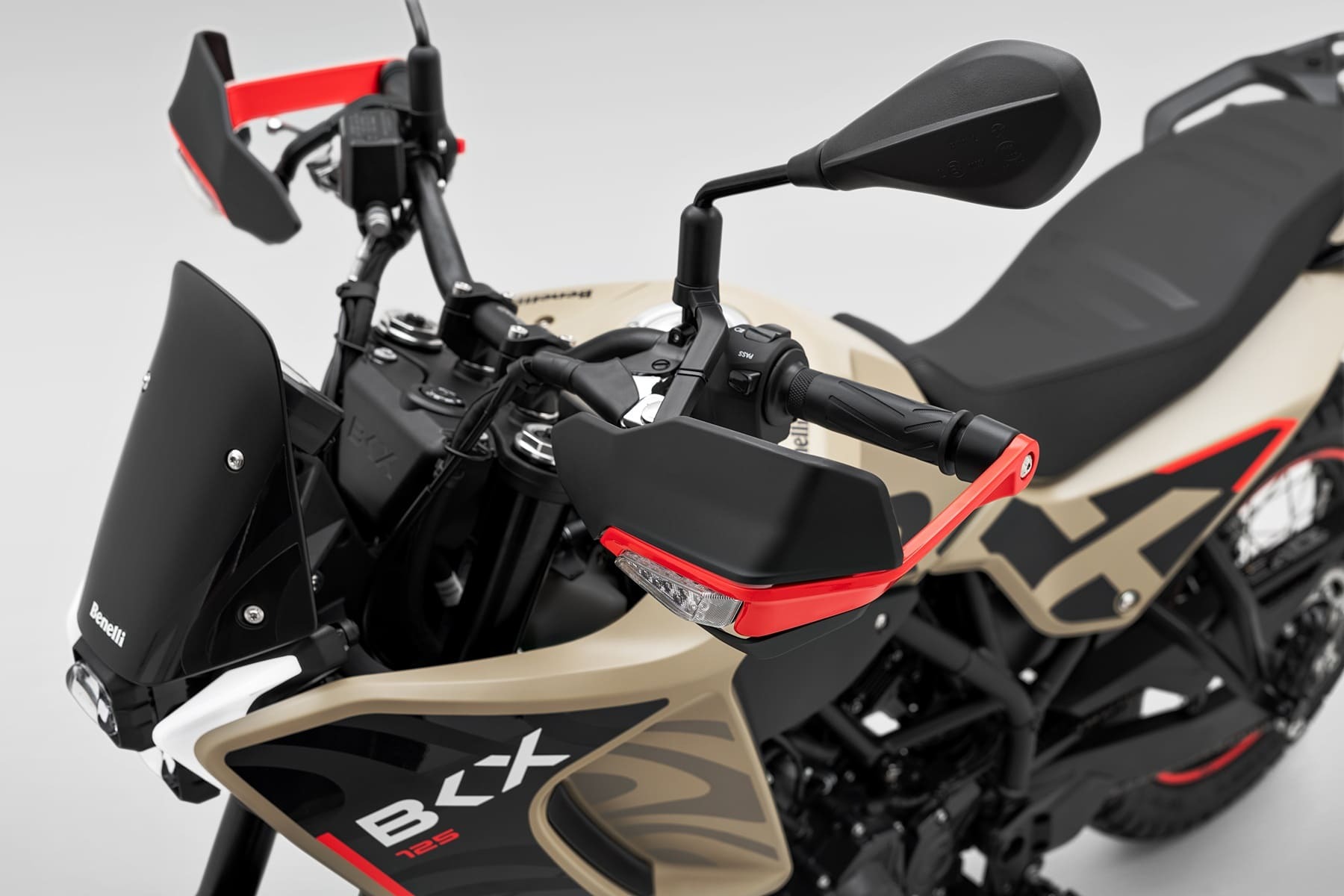 Benelli-bkx-125-s - AutoBike Close-up of a Benelli motorcycle's front end, showing beige body panels, black components, red accents, and a side mirror. - AutoBike