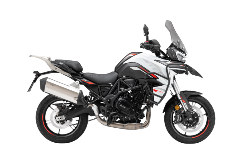 Benelli-trk-702 7 - AutoBike Side view of a white-gray adventure motorcycle with a tall windscreen and exposed exhaust system on a black background (touring-ready). Readable text: none. - AutoBike