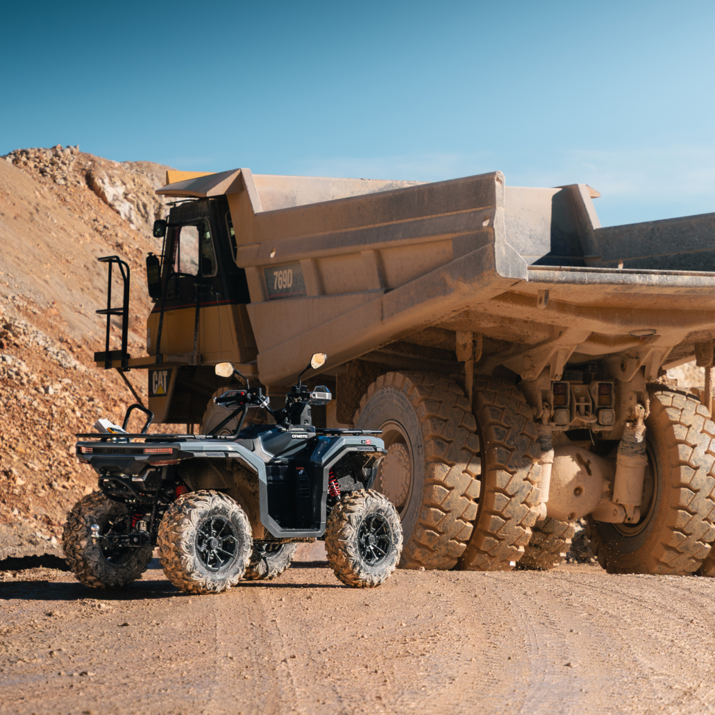 CFMOTO_CFORCE-C5_Outdoor_13-1030x1030 - AutoBike ATV parked in front of a large beige dump truck at a dusty quarry site. - AutoBike