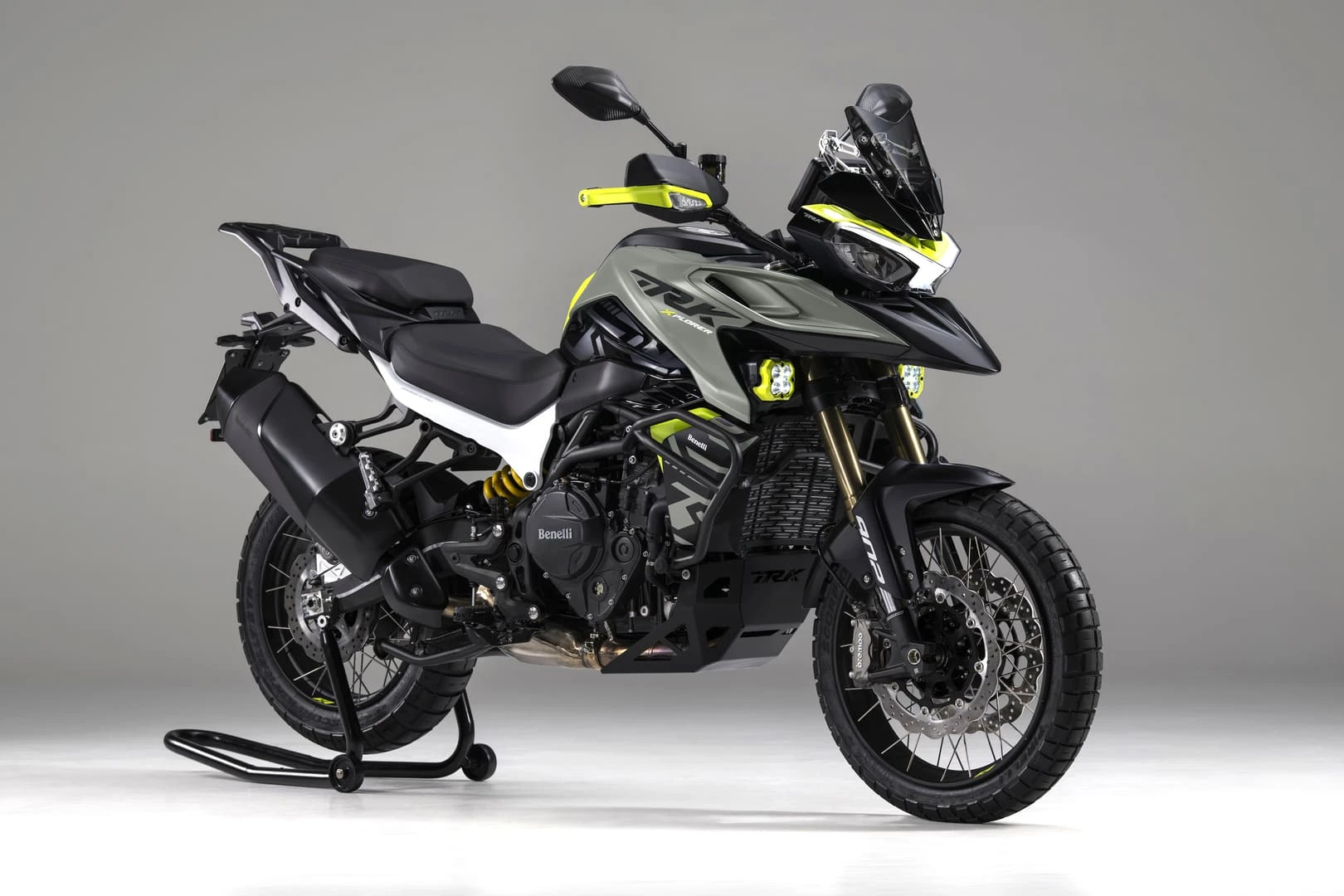 trk902_xplorer_colors_34_cement-gray 1 - AutoBike Benelli TRK 502X adventure motorcycle on a display stand, gray body with neon yellow accents, side view. - AutoBike