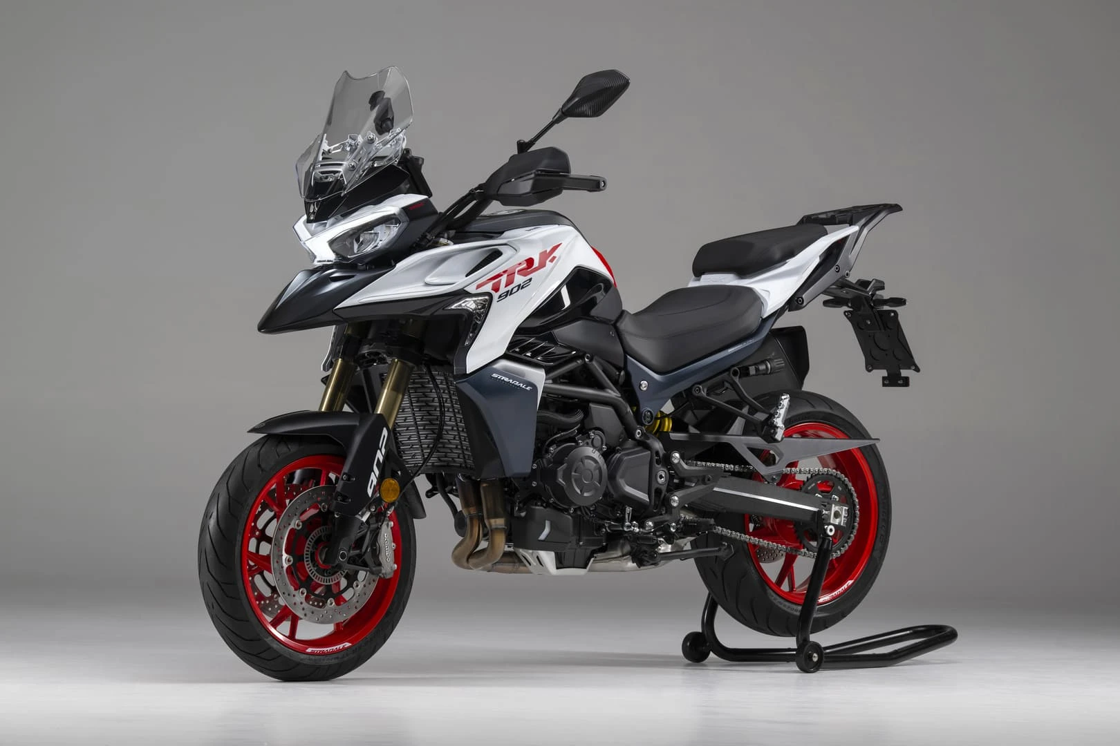 trk902stradale_02 - AutoBike White and black sport motorcycle on a rear stand in a studio, with red rims and clear windscreen. - AutoBike