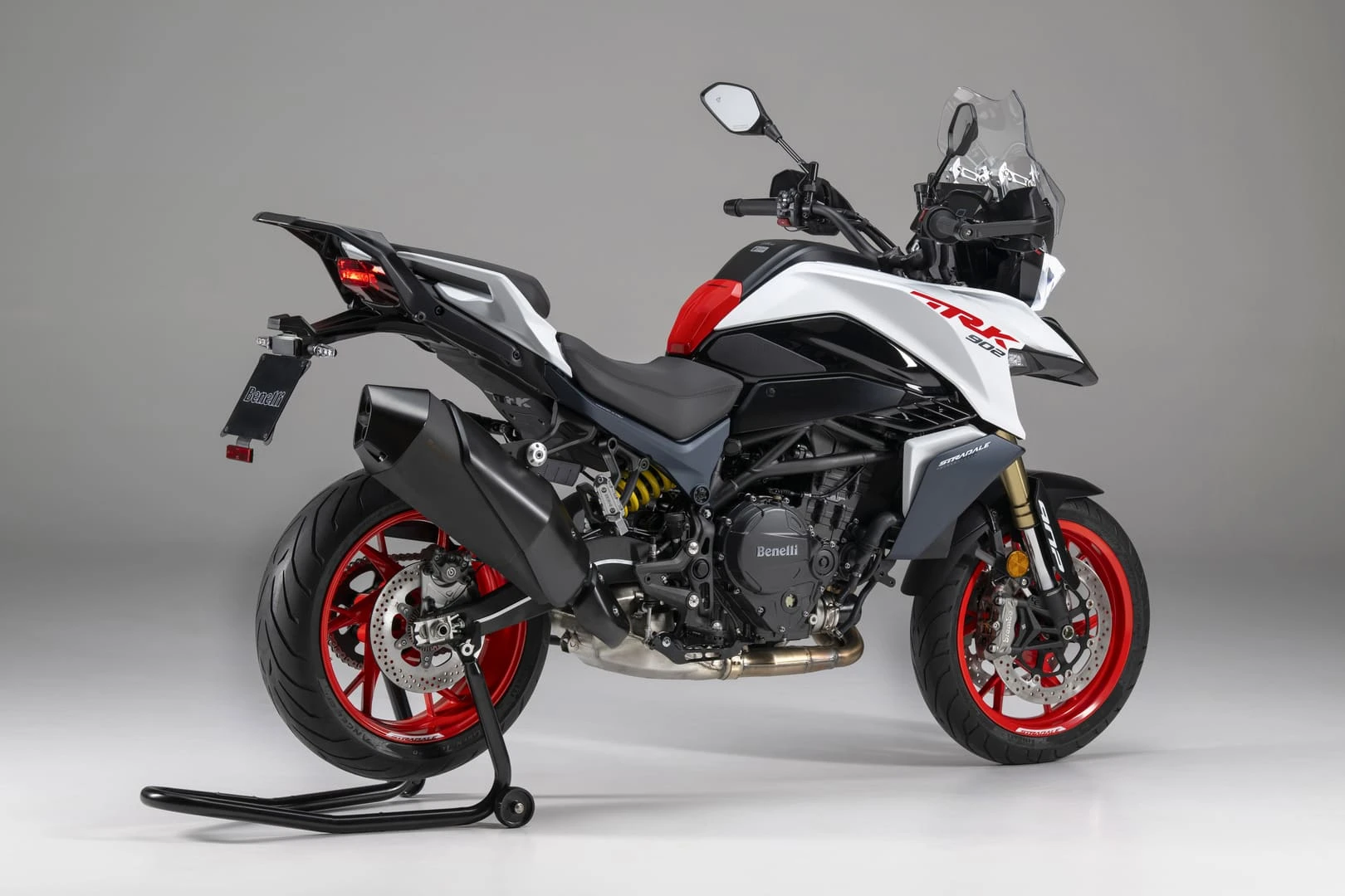 trk902stradale_05 - AutoBike Benelli TRK 502 sport-touring motorcycle on a center stand with white, black, and red body and bright red wheels - AutoBike
