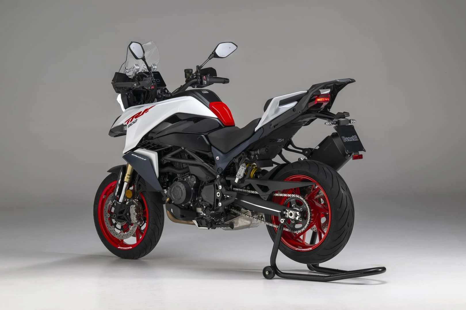 trk902stradale_06 - AutoBike Sport motorcycle on a rear stand, white body with red accents and red rims, Benelli logo on the plate to the rear. - AutoBike