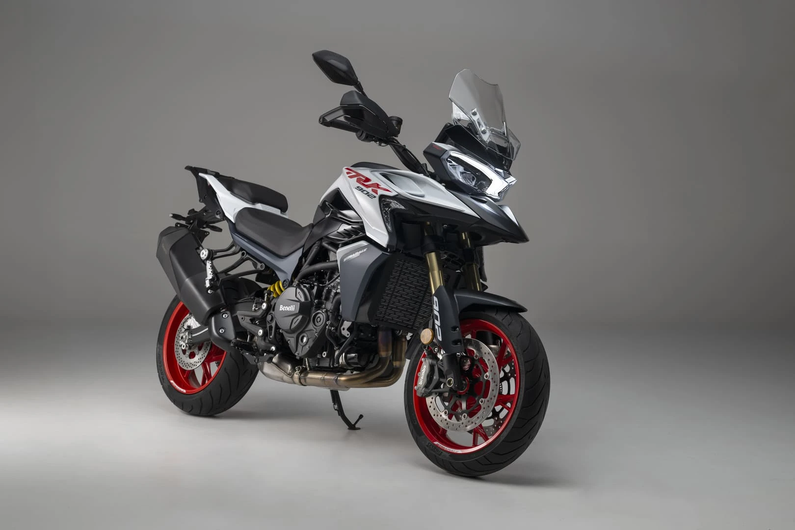 trk902stradale_09 - AutoBike White and gray Benelli sport motorcycle with red alloy wheels, shown in a studio backdrop. - AutoBike