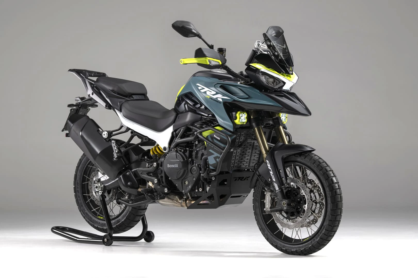 trk902xplorer_01 - AutoBike Modern dual-sport motorcycle on a center stand, black/gray with neon yellow accents and a tall windscreen behind the handlebars. - AutoBike