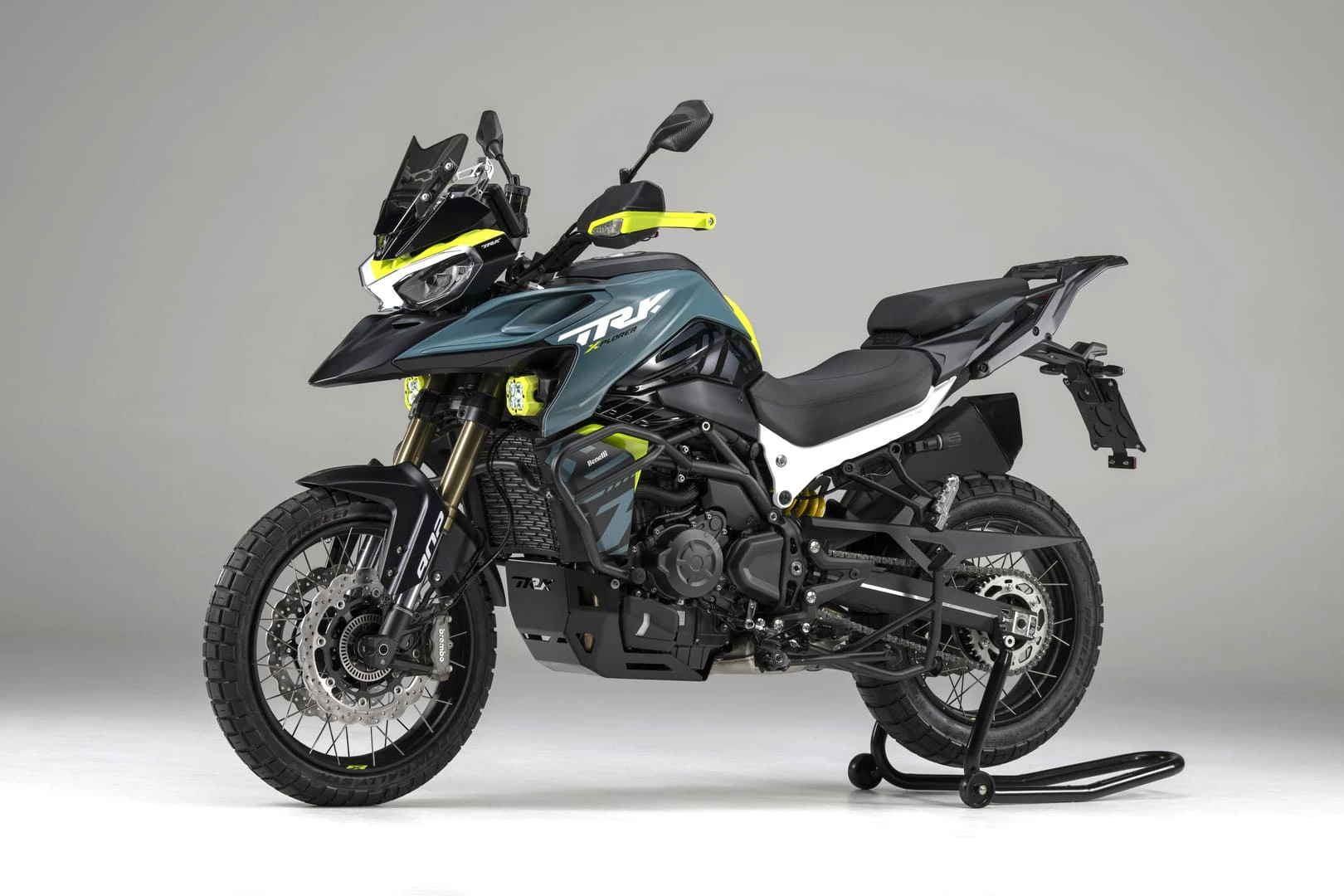trk902xplorer_02 - AutoBike Benelli TRK adventure motorcycle on a maintenance stand with neon yellow accents against a gray backdrop - AutoBike