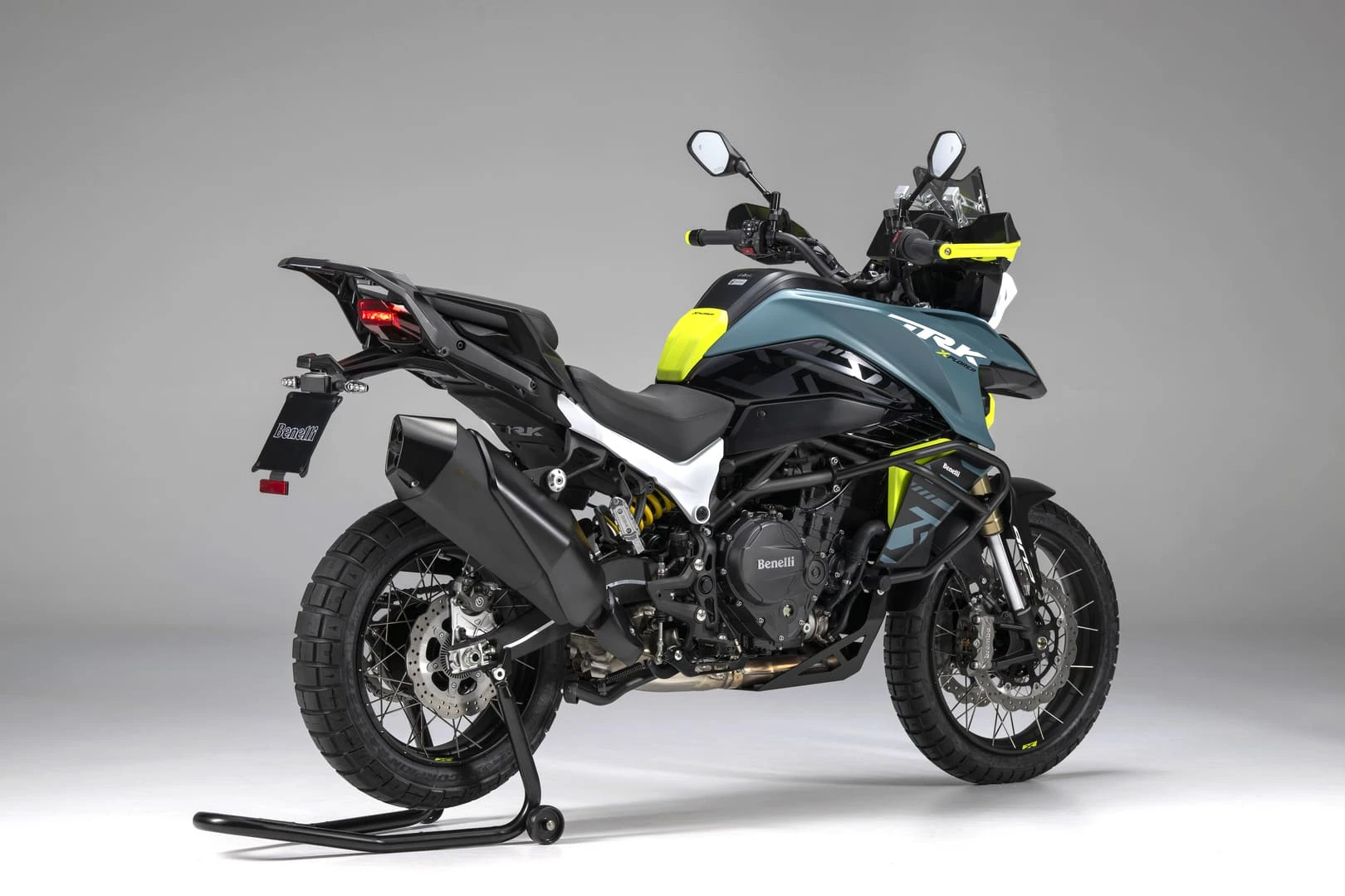 trk902xplorer_05 - AutoBike Benelli TRK adventure motorcycle on a stand with neon-yellow accents against a gray studio backdrop. - AutoBike