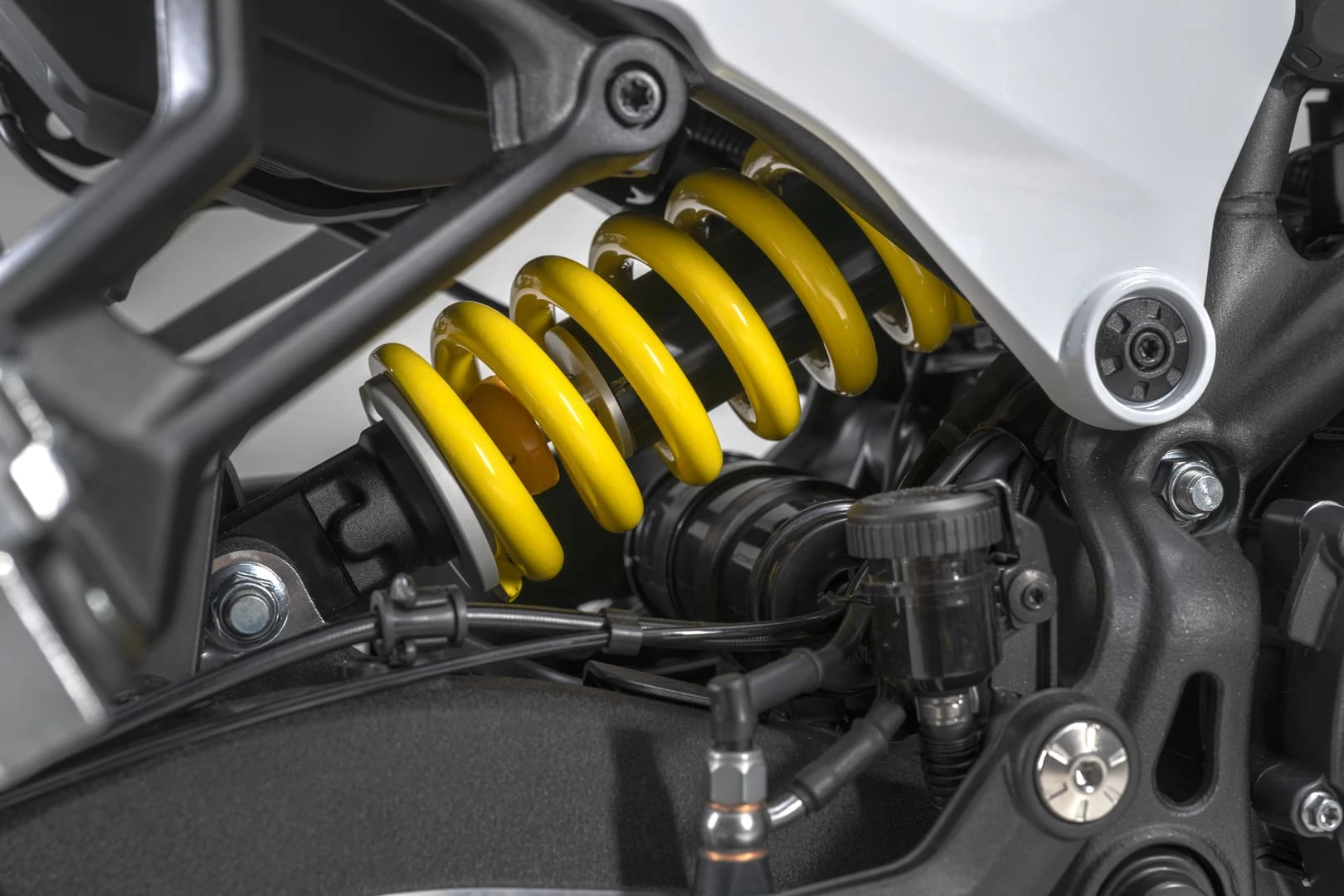 trk902xplorer_22 - AutoBike Close-up of a yellow coil spring on a motorcycle rear suspension. - AutoBike